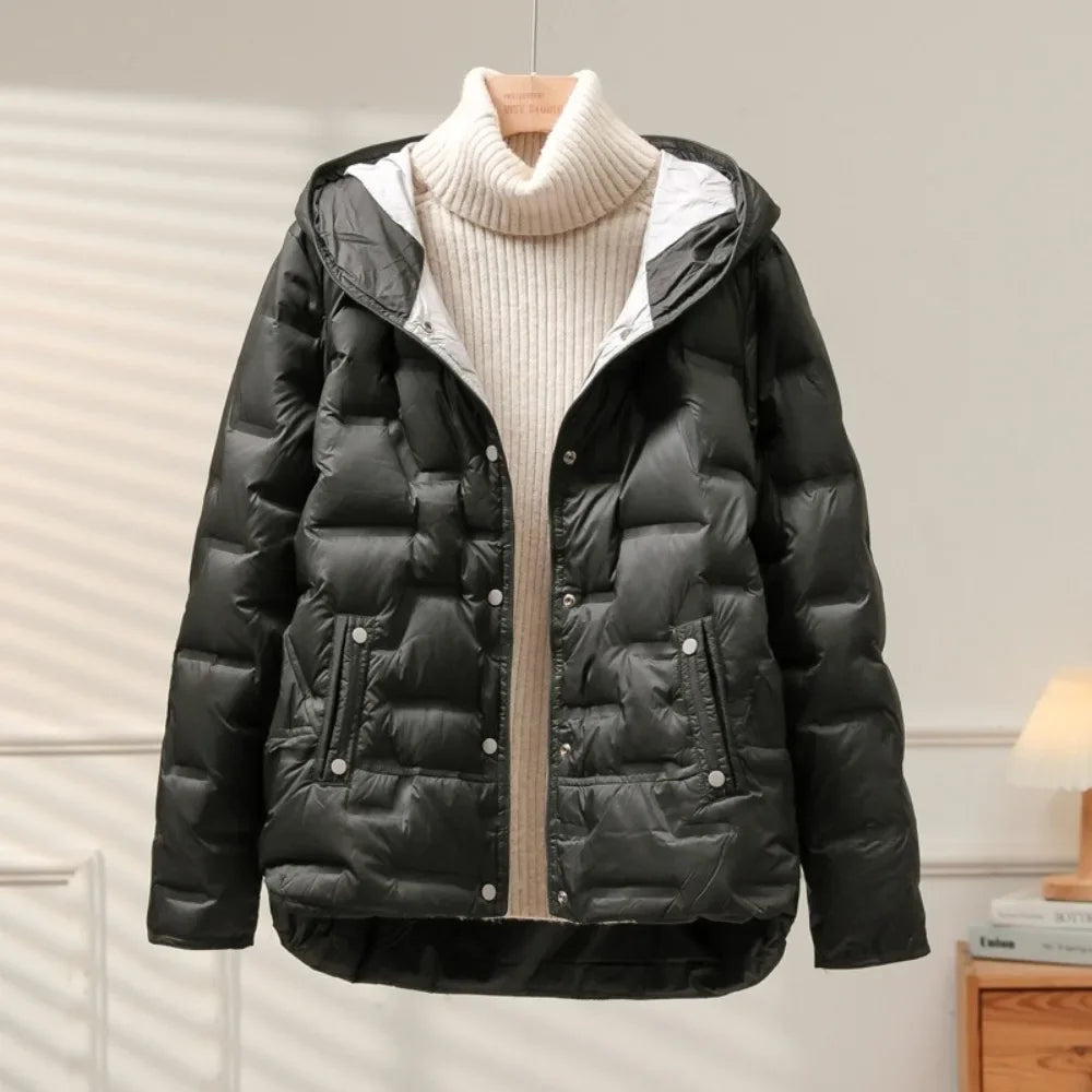 Black puffer jacket with a beige sweater underneath on a wooden hanger against a neutral background.