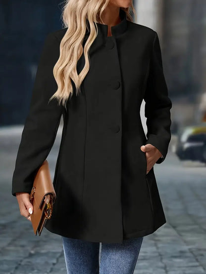 Person wearing a black coat holding a brown clutch on a blurred street background