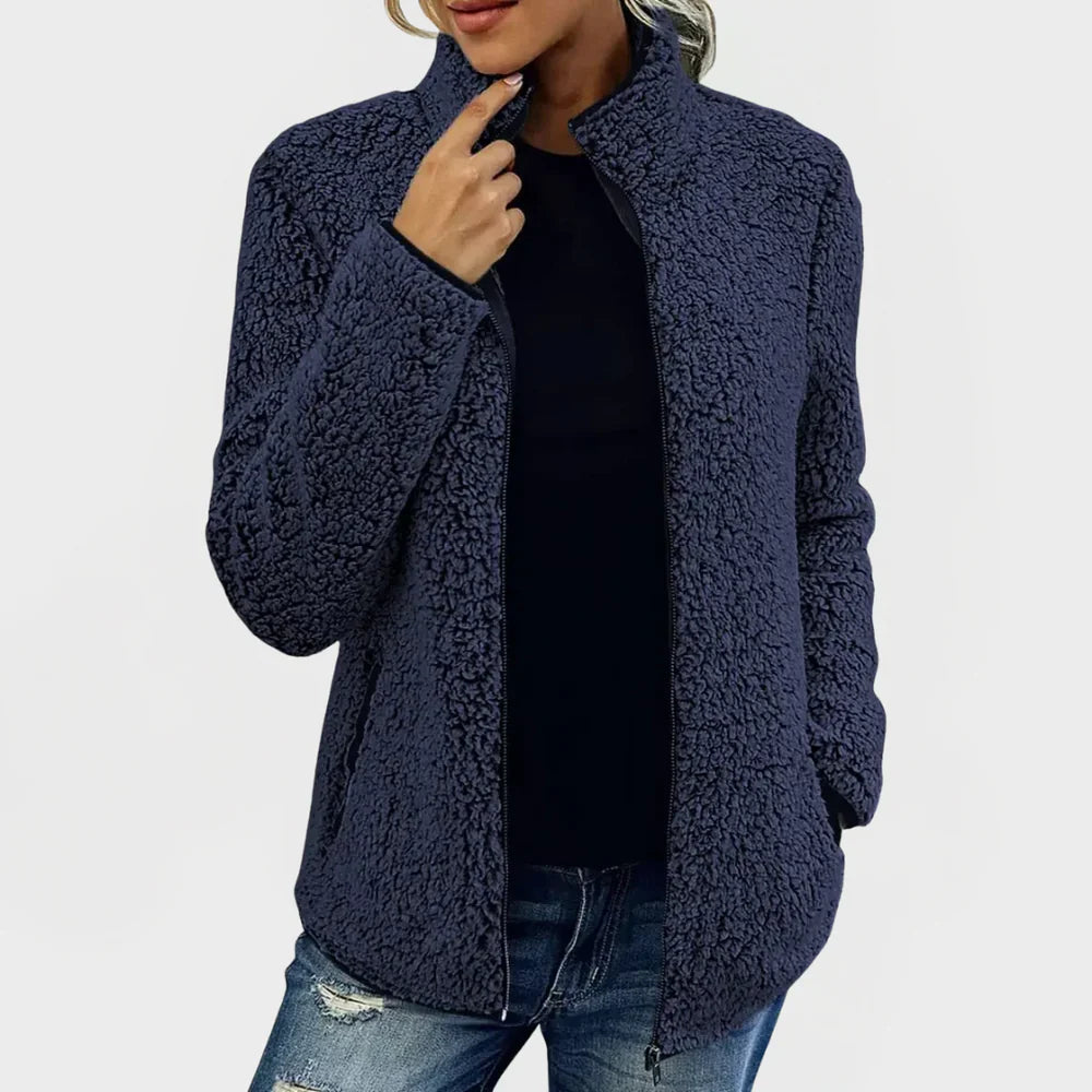 Navy blue sherpa jacket worn by a person on a white background