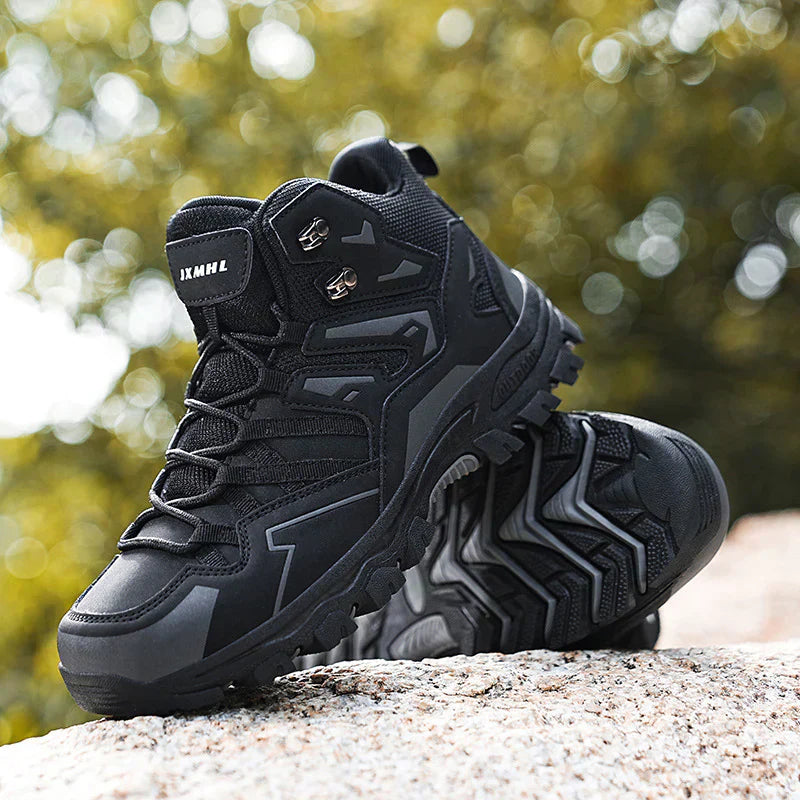 Black hiking boots on a rock with a blurred natural background