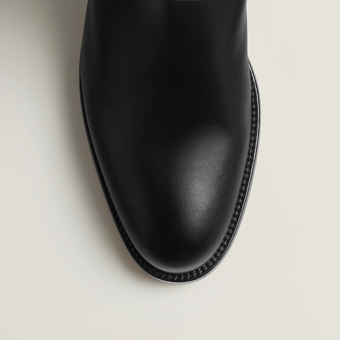 Black leather boot on a light gray background