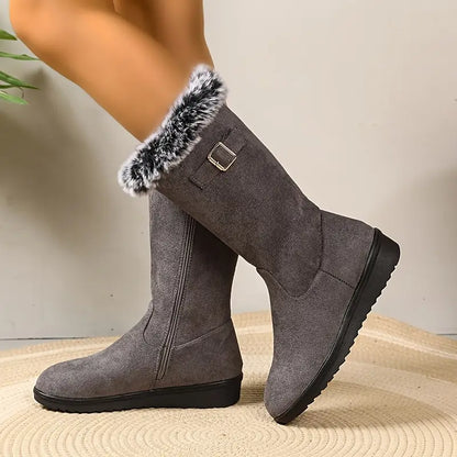 Gray knee-high boots with fur trim on a neutral background