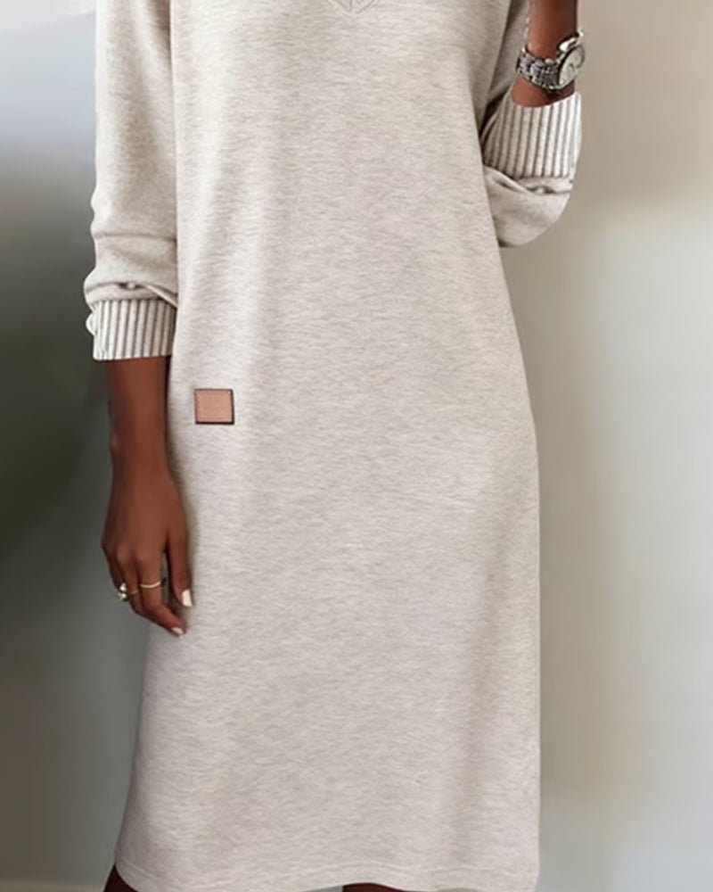 Beige dress with a brand tag on a neutral background