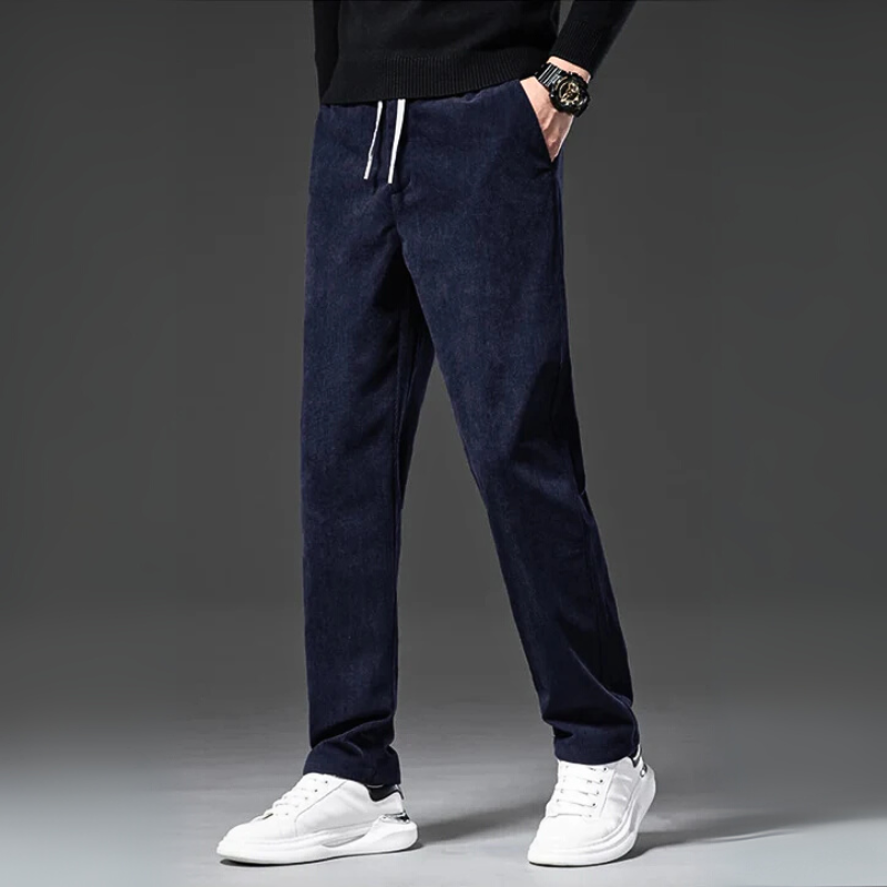 Person wearing navy blue pants with a gray background