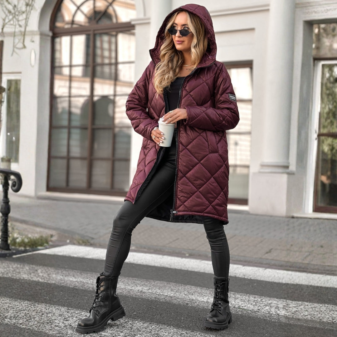 Woman wearing a burgundy quilted coat in an urban setting