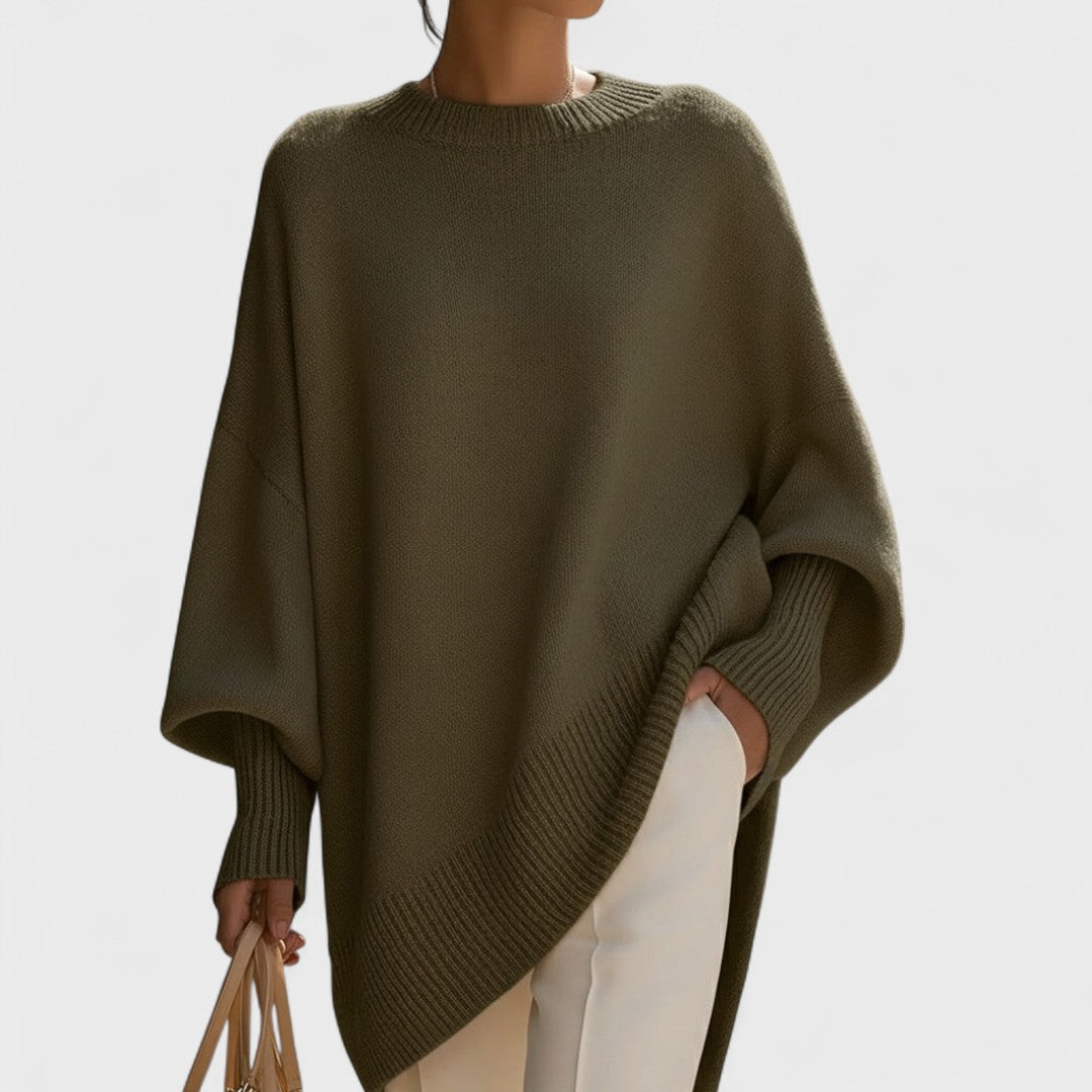Person wearing a green poncho against a plain background