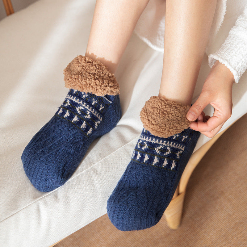 Blue socks with brown fuzzy cuffs worn by a person sitting on a couch.