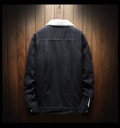 Black jacket with white collar on a wooden hanger against a wooden wall.