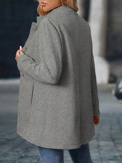 Person wearing a gray coat on a blurred street background