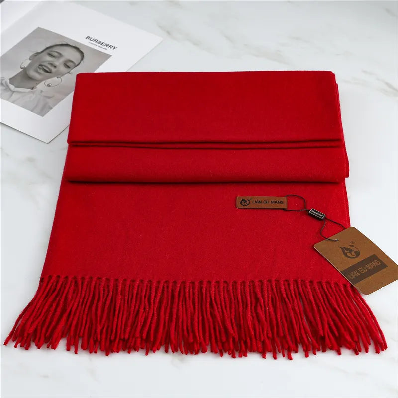Red scarf with fringes and a brand tag on a white background