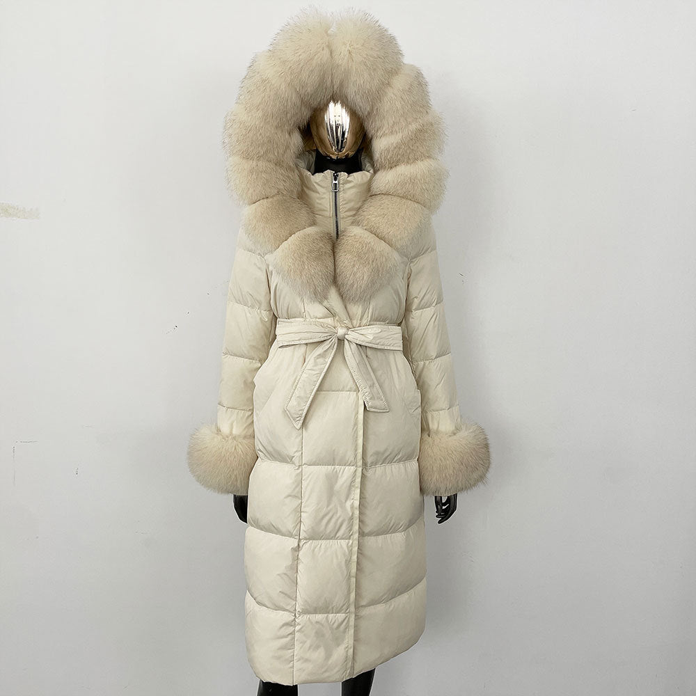 Beige puffer coat with fur hood and belt on a mannequin against a white background