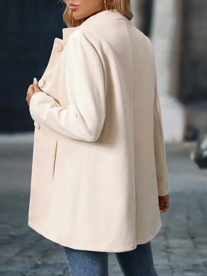 Person wearing a beige coat on a blurred street background