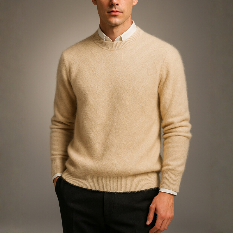 Man wearing a beige sweater over a white shirt with a gray background