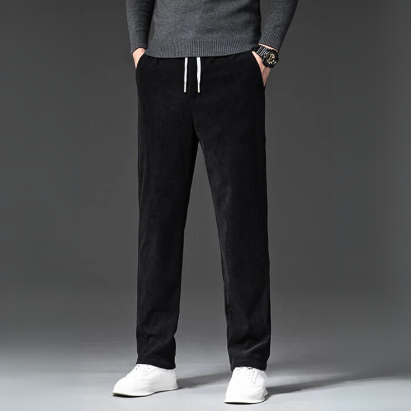 Person wearing black pants and a gray sweater on a gray background