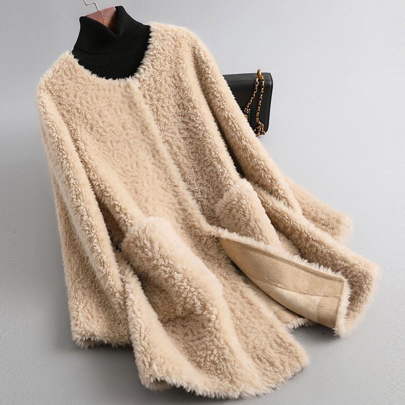 Beige fluffy sweater draped over a black garment on a gray background