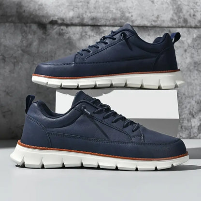 Navy blue sneakers with white soles on a gray background