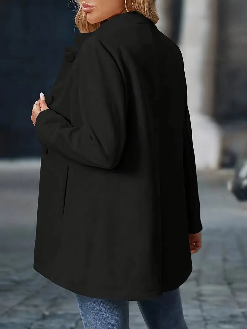Person wearing a black coat on a blurred street background