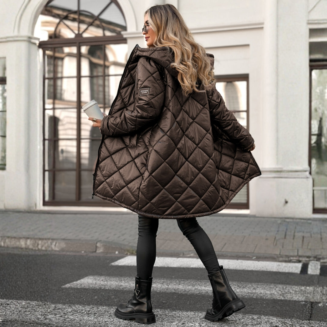 Woman wearing a brown quilted coat walking on a street.