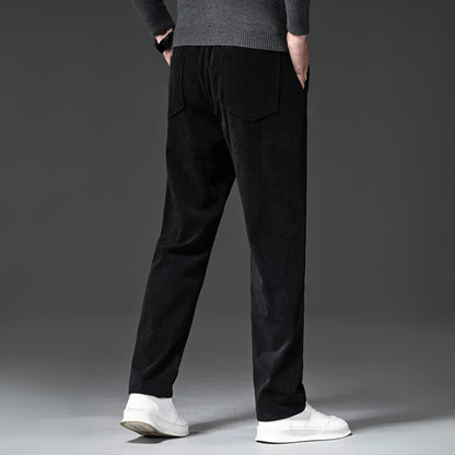 Person wearing black pants and white shoes on a gray background
