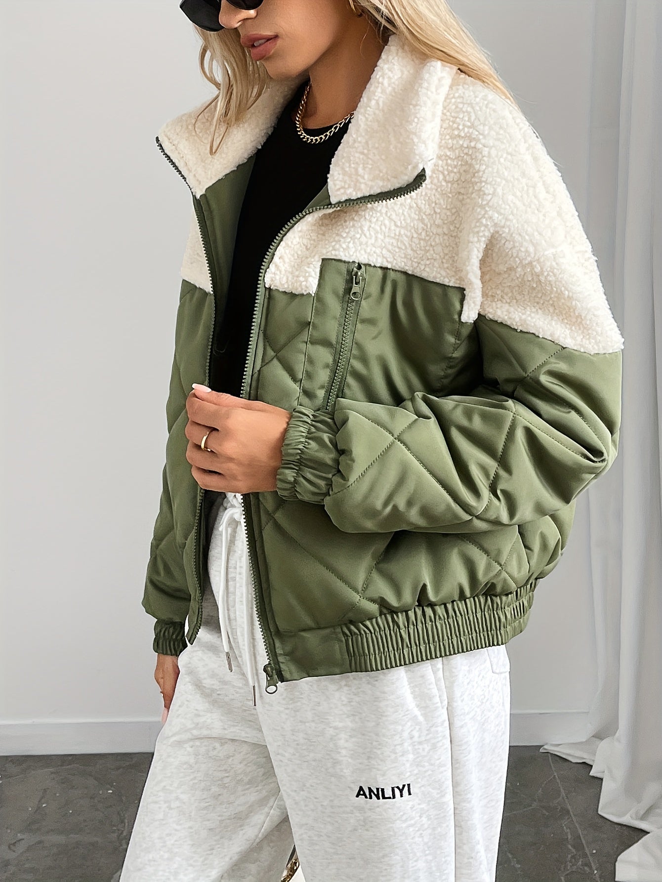 Person wearing a green and white jacket with a plain background