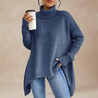 Person wearing a blue sweater holding a coffee cup against a beige background