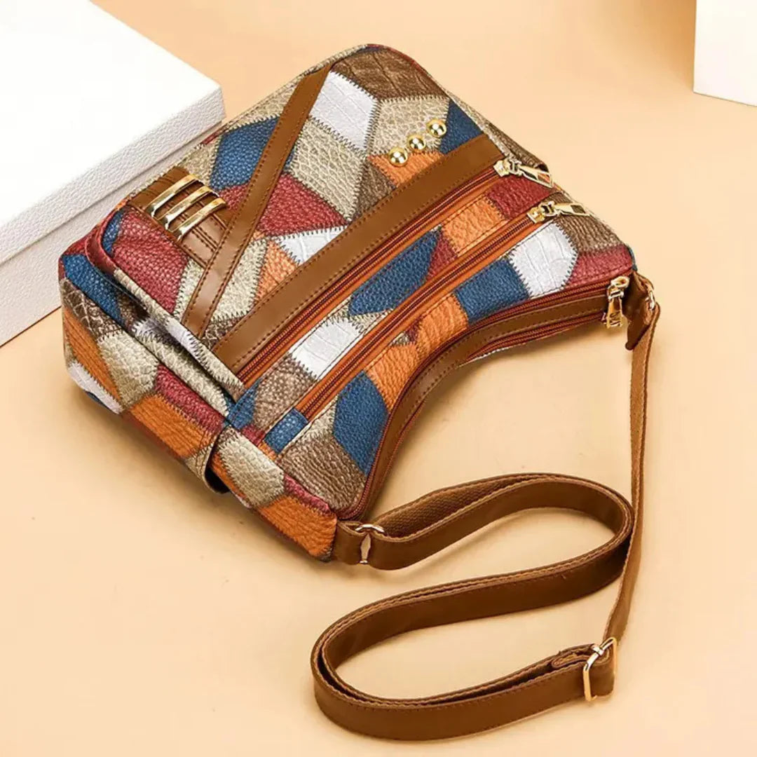Multicolored patterned handbag with a brown strap on a beige background