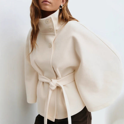 Beige coat with a belt worn by a person on a white background