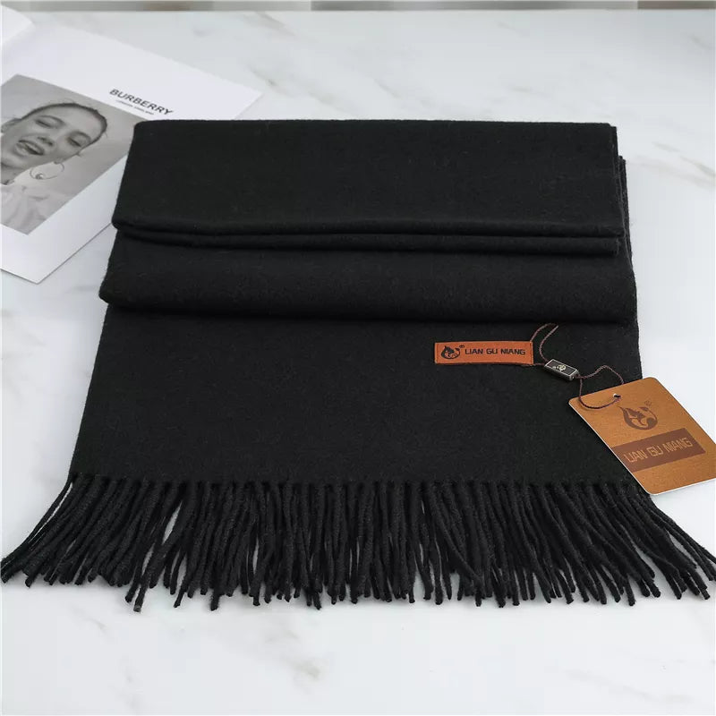 Black scarf with tassels on a white surface
