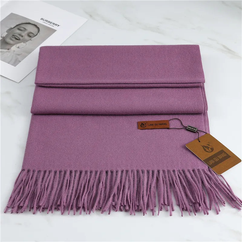 Purple scarf with fringes and a tag on a white surface