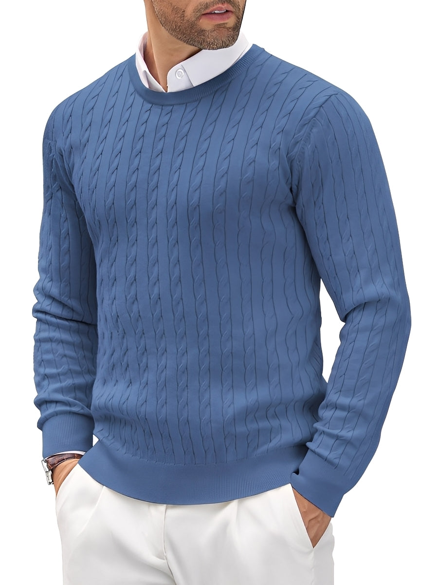 Man wearing a blue cable knit sweater with a white shirt underneath on a white background