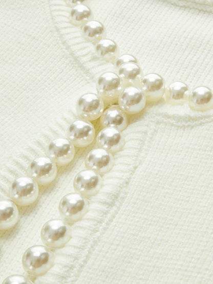 Close-up of a pearl necklace on a textured white background