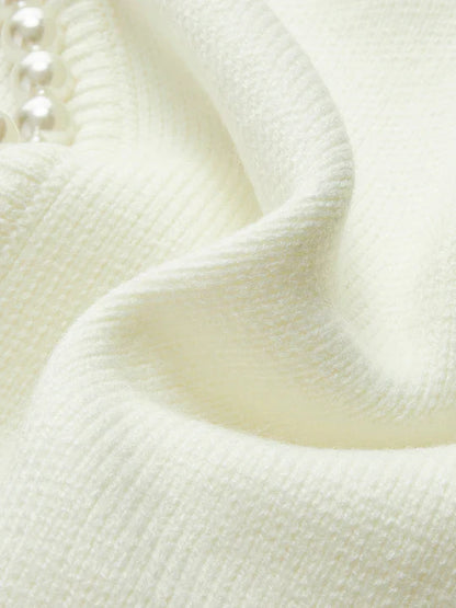 Close-up of textured white fabric with a pearl-like bead.