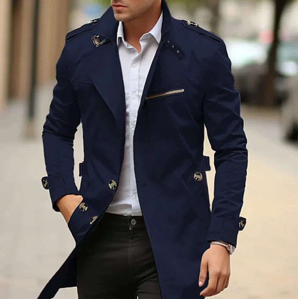 Man wearing a navy blue coat over a white shirt on a blurred street background