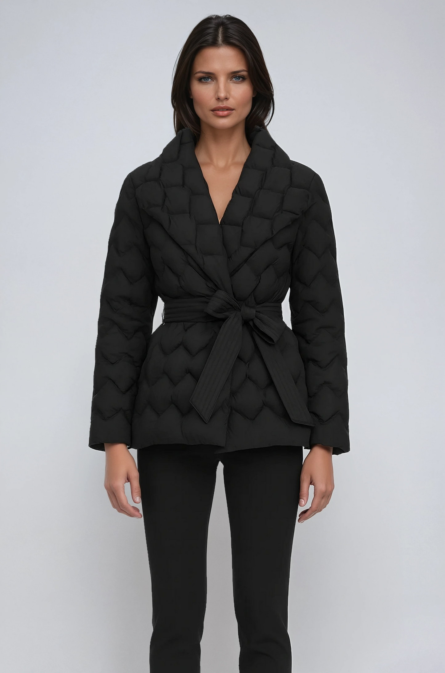 Woman wearing a black quilted jacket on a white background