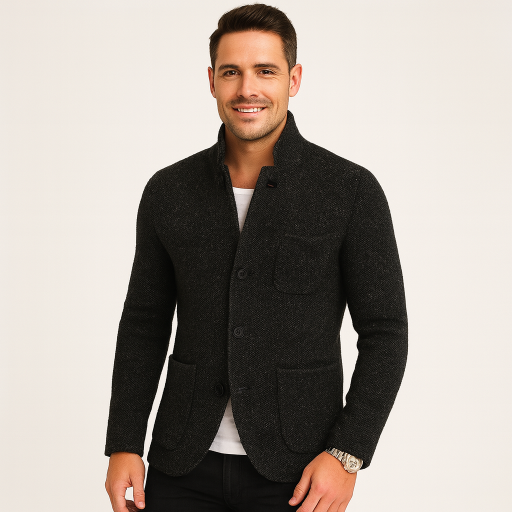 Man wearing a dark gray blazer on a light background