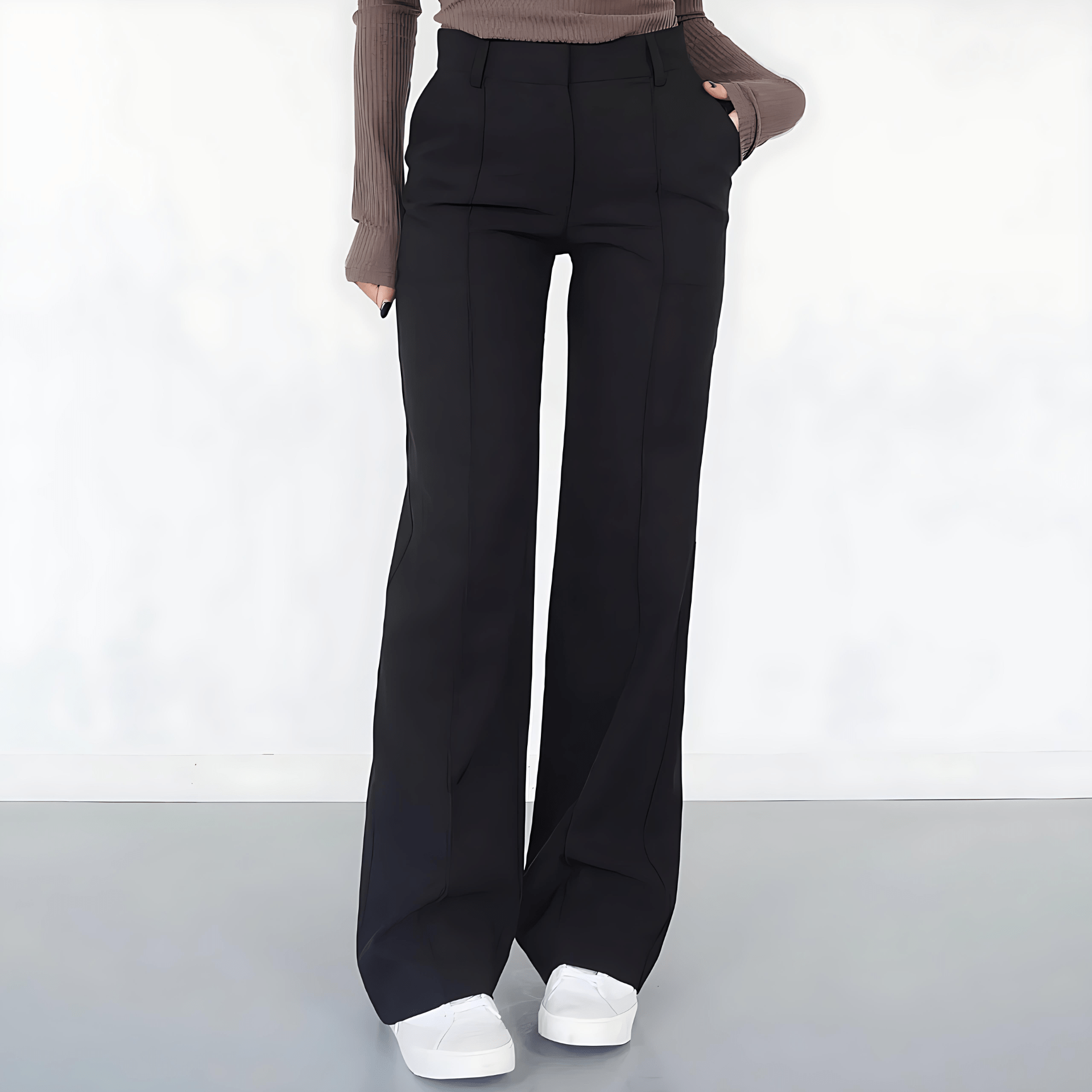 Person wearing black wide-leg pants on a white background