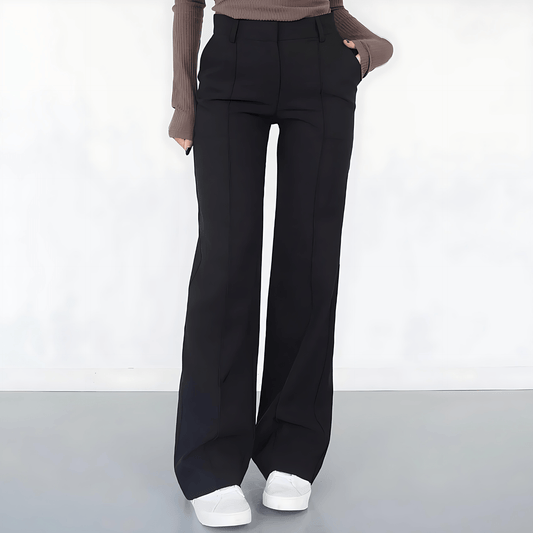 Person wearing black wide-leg pants on a white background