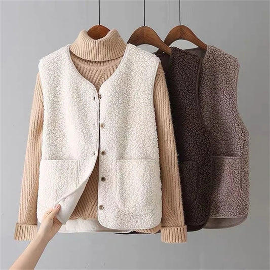 Two vests, one beige and one brown, on hangers against a gray background.