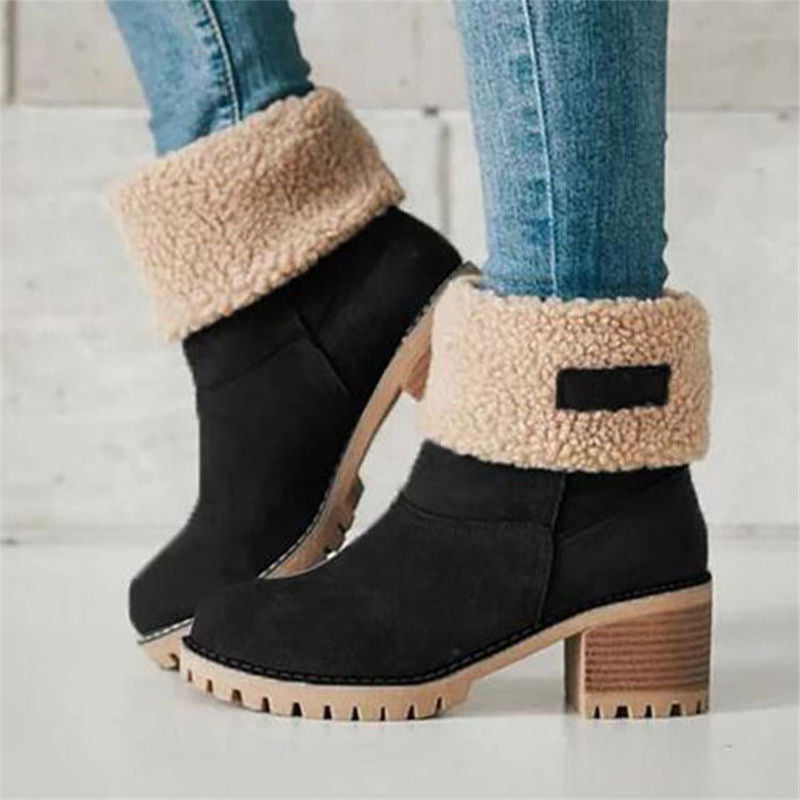 Black ankle boots with beige sherpa lining worn with blue jeans on a light background