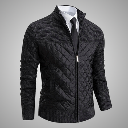 Black quilted jacket with a white shirt and tie on a gray background