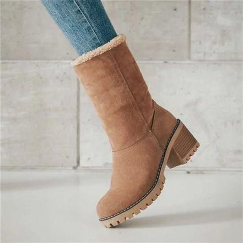 Tan suede boot with fur lining on a light wooden floor.