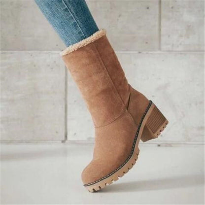 Tan suede boot with fur lining on a light wooden floor.