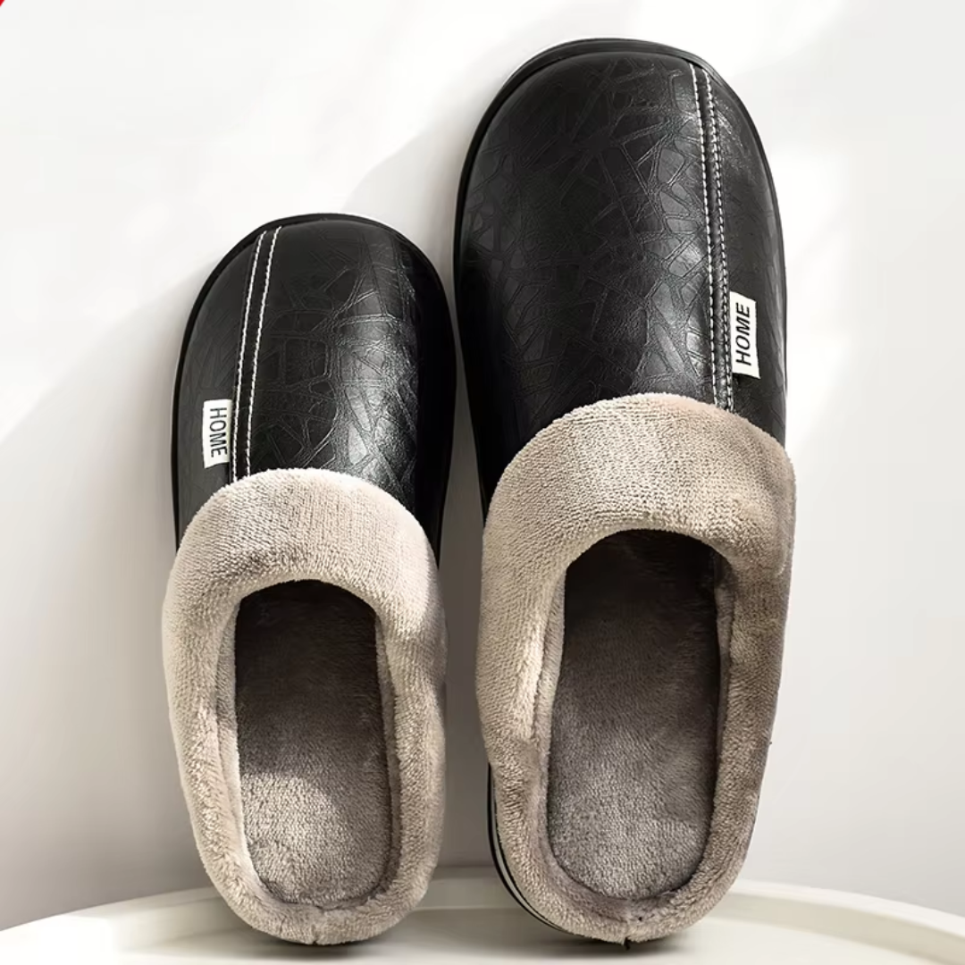 Pair of black and gray slippers with 'HOME' label on a white background