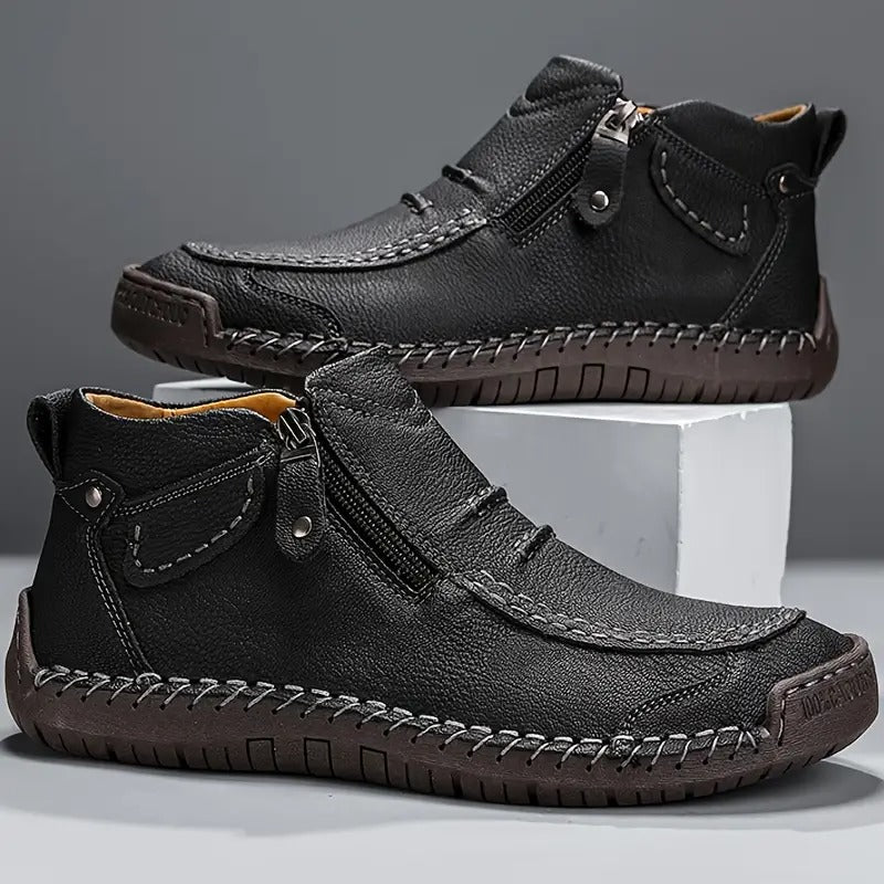 Black leather shoes with zippers on a gray background