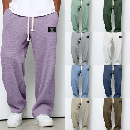 Purple sweatpants worn by a person with additional color options displayed on a white background.