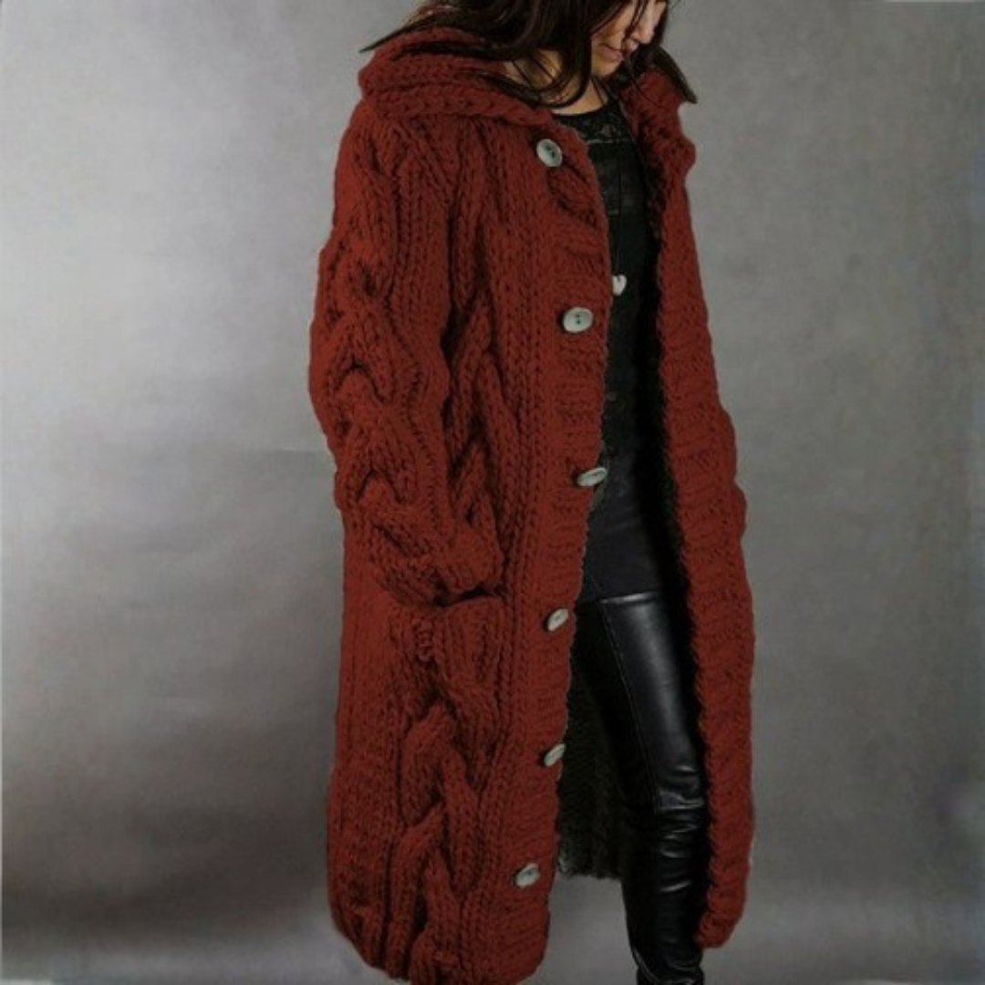 Red knitted coat worn by a person on a plain background