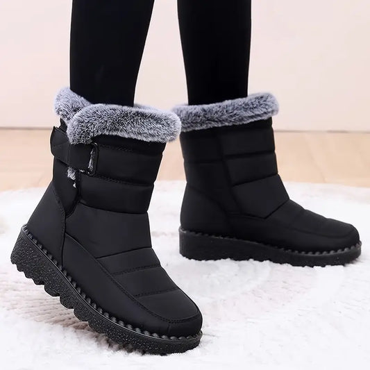 Black winter boots with gray fur trim on a light background