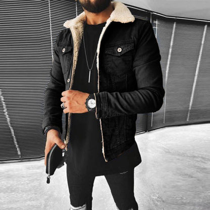 Person wearing a black denim jacket with shearling lining in an urban setting.