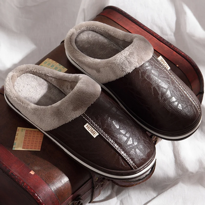 Pair of brown slippers with gray fur lining on a white surface