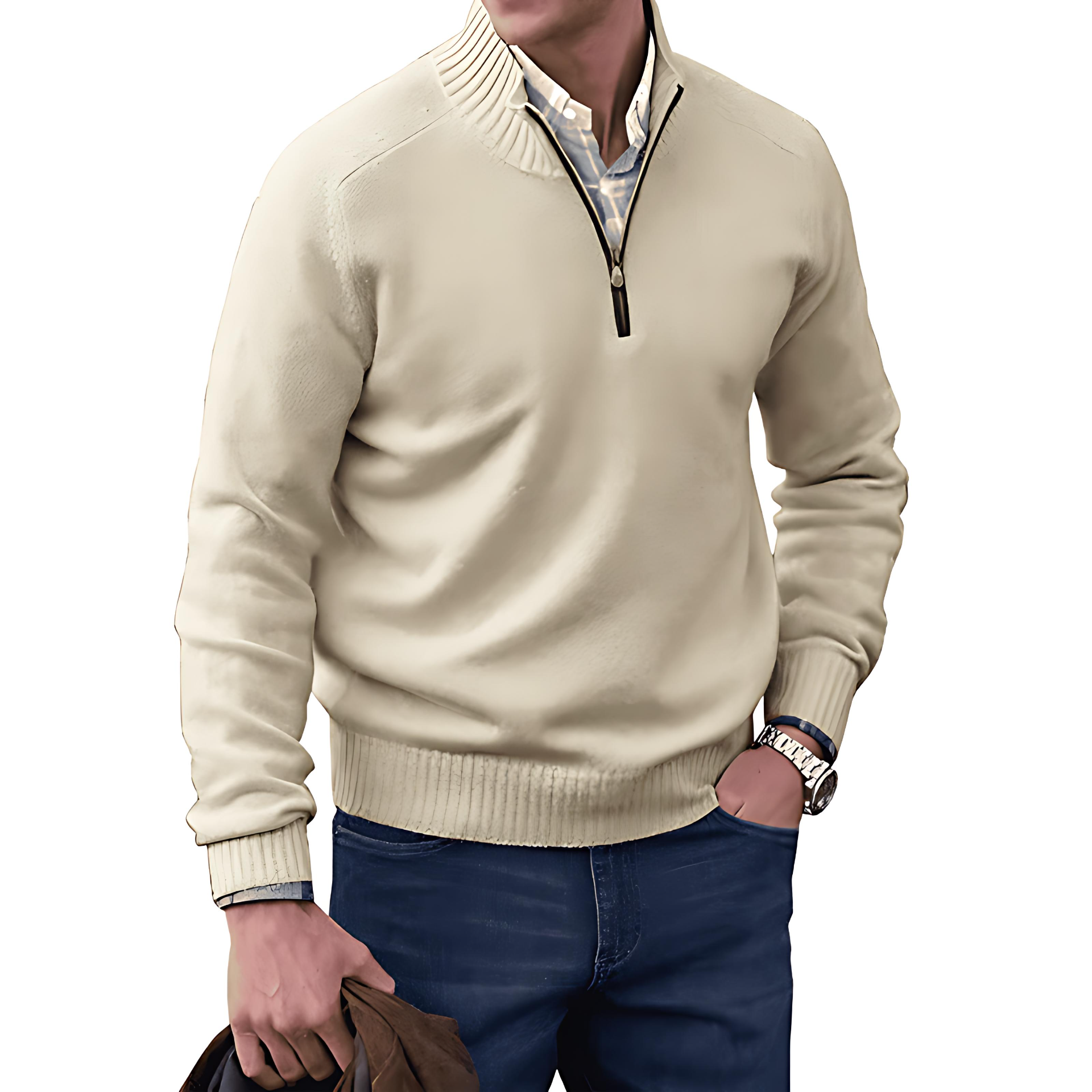 Man wearing a beige half-zip sweater and blue jeans on a white background